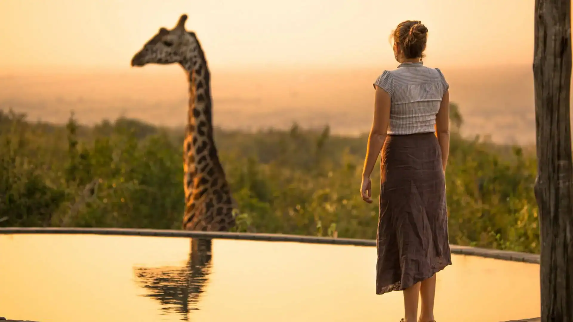 Kvinna som står framför en giraff på en av hennes safariresor.