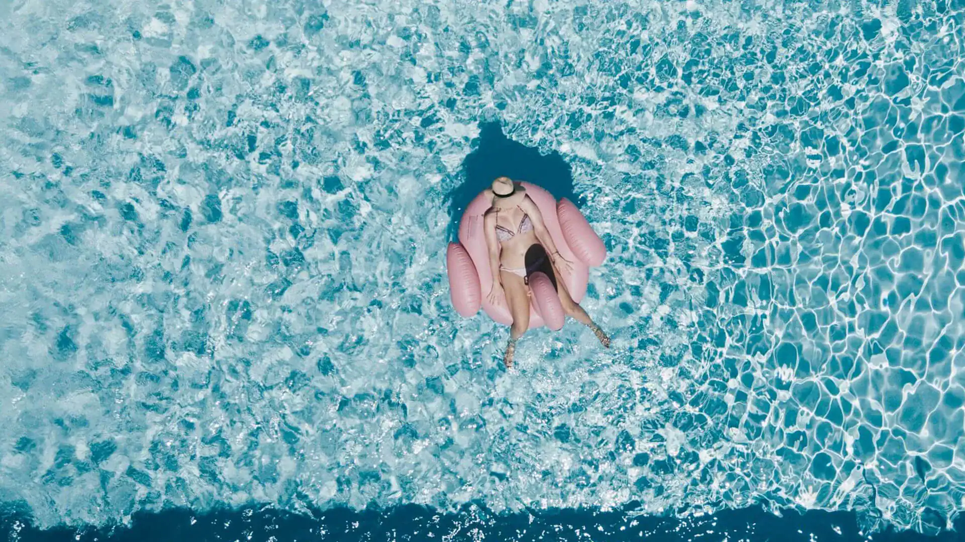 Kvinna som ligger på en badring i vattnet på en av sina solresor.